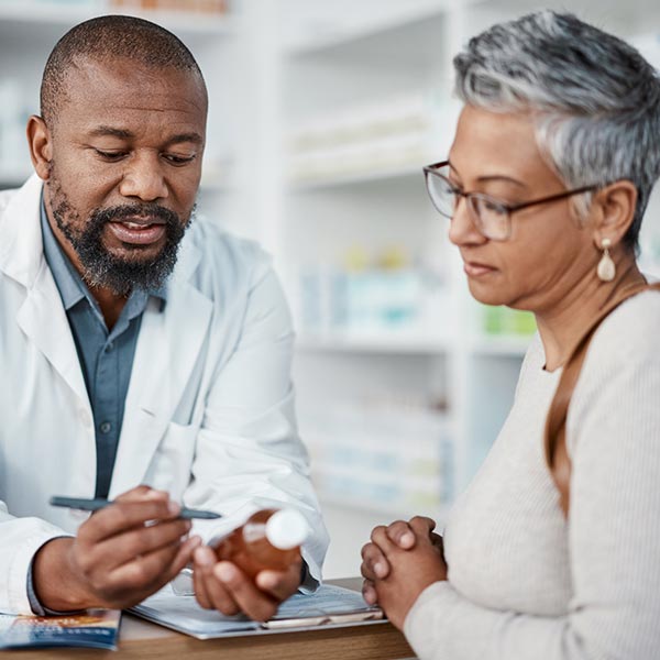Pharmacist assists senior woman with prescriptions.